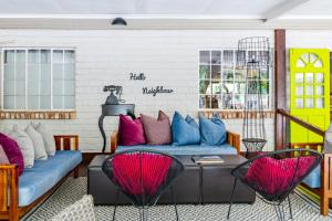 a living room with a blue couch and colorful pillows at Gondwana Damara Mopane Lodge in Mopane Pos +18 photos