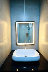 a bathroom with a sink with a mirror at David Residency in Madurai +57 photos