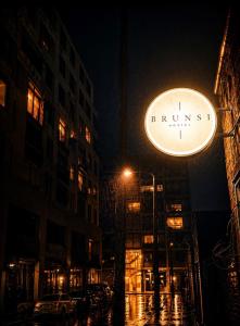 a sign for a business on a city street at night at Brunsi Hostel in Melbourne