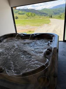 a bath tub filled with water next to a dirt road at Refugiul din Deal in Mărgău