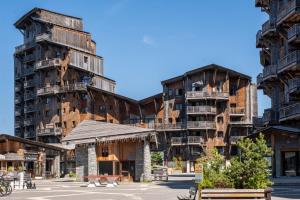 a large building with two tall wooden buildings at Résidence Pierre & Vacances Premium L'Amara in Avoriaz
