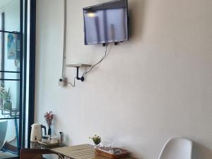 a tv hanging on a wall in a living room at Doichang Riverhouseดอยช้างริเว่อเฮาส์ in Ban Huai Khai