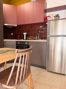 a kitchen with a table and a stainless steel refrigerator at Aurora Suite in Xanthi