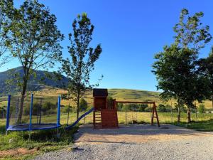 a playground with a swing in a field at Refugiul din Deal in Mărgău
