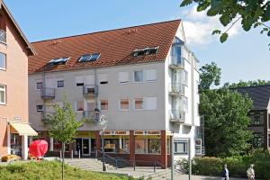 ein großes weißes Gebäude mit einem roten Dach in der Unterkunft Appartements DW16~17~19 in Dortmund in Dortmund
