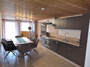 a kitchen with a table and chairs and a dining room at Ferienwohnung Weindl Lucia in Kollnburg