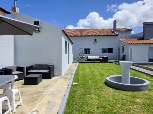 a backyard with a lawn with a table and chairs at MC House in Ribeira Grande