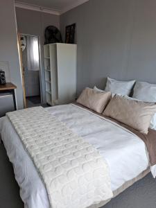 a large white bed in a bedroom at Koeroebees 1 in Springbok +2 photos