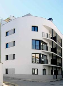 a white building withwindows and balconies on the side of it at Apartamentos TDM in Tossa de Mar