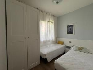 a bedroom with two beds and a window at Villaggio Michelangelo in Bibione