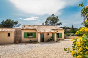 a house with a green door and a gravel driveway at Villa la Rabassa in Lauris