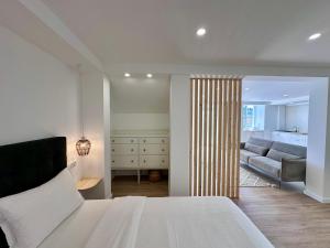 a bedroom with a bed and a living room with a couch at UpTown Apartments in Horta