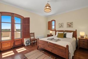 a bedroom with a bed and a large window at Casa Do Cerro in Luz de Tavira +24 photos