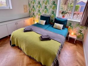 a bedroom with a large bed with a yellow blanket at De Oude Kleuterschool in Zoelen