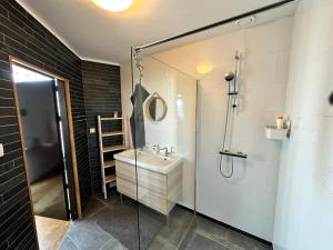 a bathroom with a sink and a glass shower at De Oude Kleuterschool in Zoelen +35 photos