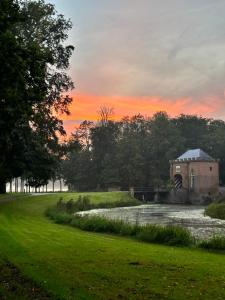 an old building in a field at sunset at De Oude Kleuterschool in Zoelen