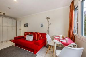 a living room with a red couch and a table at Bungalow Westerland Kampstrasse in Westerland +12 photos