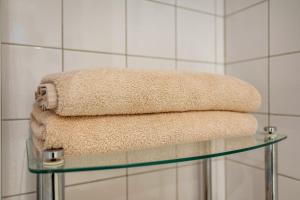 a stack of towels on a glass table in a bathroom at Bungalow Westerland Kampstrasse in Westerland