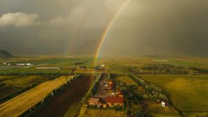 an aerial view of a rainbow over a field at Arnanes Country Hotel in Höfn