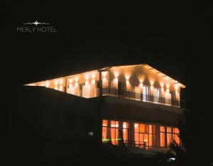 a building with an airplane flying over it at night at Merly Hotel in Përmet