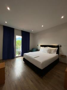 a bedroom with a large bed and a large window at Merly Hotel in Përmet +29 photos