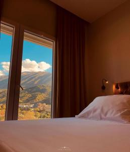 a bedroom with a bed and a large window at Merly Hotel in Përmet