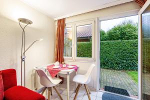 a small room with a table and chairs and a window at Bungalow Westerland Kampstrasse in Westerland