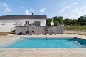 a swimming pool in front of a house at Villa Alfaro in Saint-Cernin-de-Larche