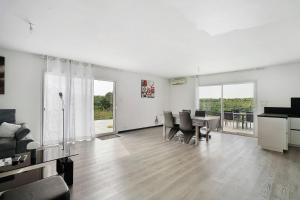 a white living room with a table and chairs at Villa Alfaro in Saint-Cernin-de-Larche