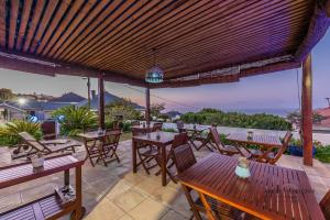 a patio with tables and chairs and a view of the ocean at Aquamarine Guest House in Mossel Bay