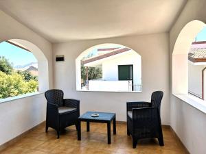 a room with two chairs and a table and two windows at Sole e Luna in San Vito +53 photos