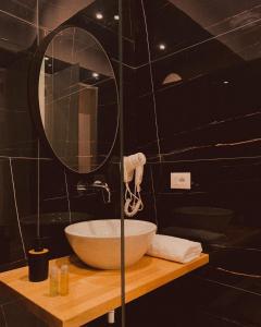 a bathroom with a sink and a mirror at Merly Hotel in Përmet