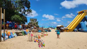 a girl standing on a beach with a playground at Topanga 17 in Uvongo Beach