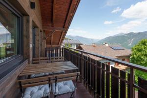 a balcony with a bench and a view of the mountains at Mountain View Suites in Tisens