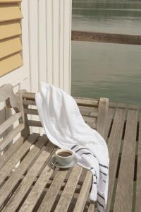 a cup of coffee on a wooden bench with a blanket at VILLA LINDE Seehotel in Bodman-Ludwigshafen