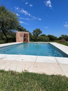 a swimming pool with a brick structure in a yard at Al pie de la Sierra in Pueblito