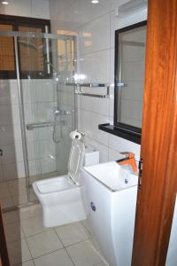 a bathroom with a toilet and a glass shower at jPALACE in Bonamoussadi +24 photos