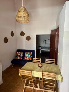 a dining room with a table and chairs and a couch at Casinha Serrinha in Mértola