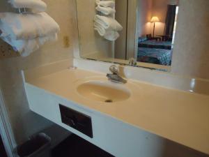 a bathroom with a sink and a mirror and towels at Welborn Motel - Hamptonville in Hamptonville