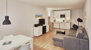 a living room with a couch and a kitchen at Düne, App 9 in Duhnen
