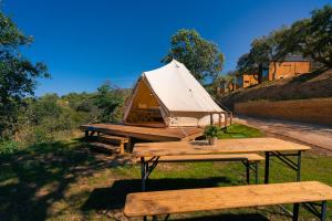 a tent sitting on a picnic table with two benches at Kampaoh Alquézar in Alquézar +74 photos