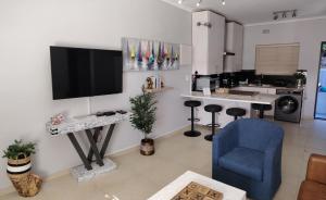 a living room with a tv and a blue chair at 3 Sea View Lodge in Langebaan