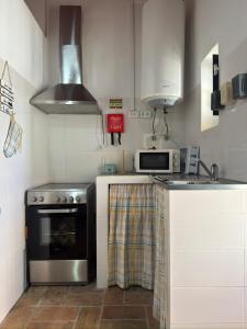 a kitchen with a stove and a microwave at Casinha Serrinha in Mértola +4 photos