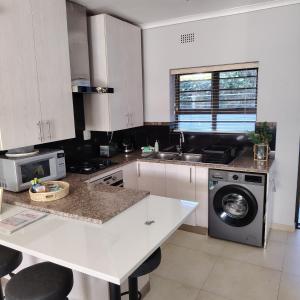 a kitchen with a sink and a washing machine at 3 Sea View Lodge in Langebaan +10 photos