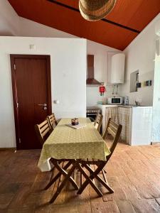 a kitchen with a table and chairs in a room at Casinha Serrinha in Mértola