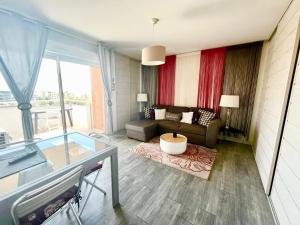 a living room with a couch and a glass table at Casamea - Vue Mer, Clim & Parking, Proche Plage in Ajaccio