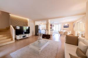 a living room with a couch and a tv at Villa Mastrissa Taormina - Private Villa with 2 pool in Taormina