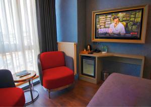 a living room with a red chair and a tv at 216 Eagle Palace Suite in Istanbul