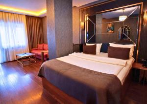 a hotel room with a large bed and a chair at 216 Eagle Palace Suite in Istanbul