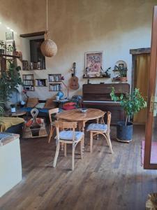 a living room with a wooden table and a piano at chambre à la campagne in Saint-Mathieu